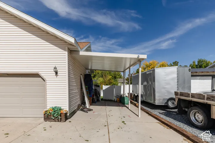 Attached carport with a concrete driveway, providing covered parking