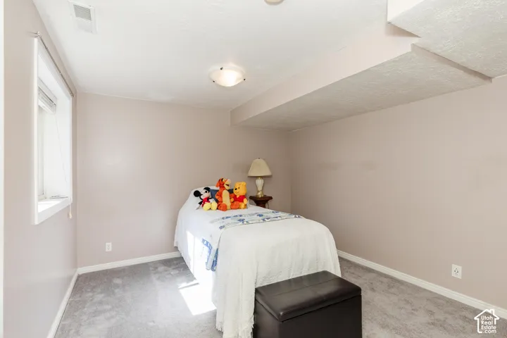 Window with white trim, wall-to-wall carpeting, and a flush-mount ceiling light