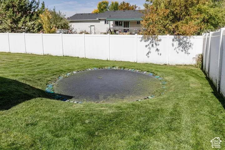 Expansive backyard with a level lawn and a white privacy fence