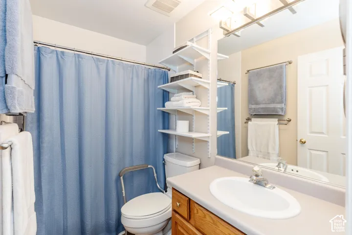 Built-in shelving, vanity with integrated sink, overhead lighting, and wall-mounted mirror