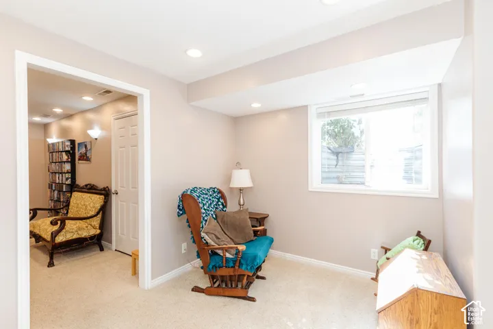Recessed lighting, light-colored walls, carpeted flooring, a window with blinds, and a paneled door
