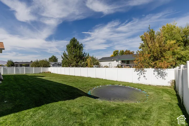 Expansive lawn with a white privacy fence