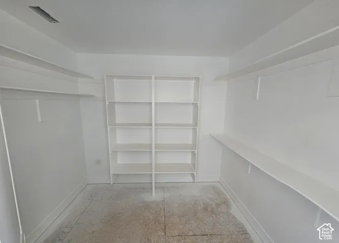 Built-in shelving unit, multiple hanging racks, and upper storage shelves