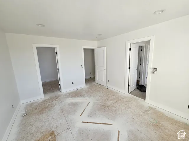 Recessed lighting, white walls, white trim, multiple doorways, and unfinished subfloor