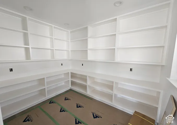 Extensive built-in shelving and cabinetry with a pristine white finish and recessed ceiling lighting
