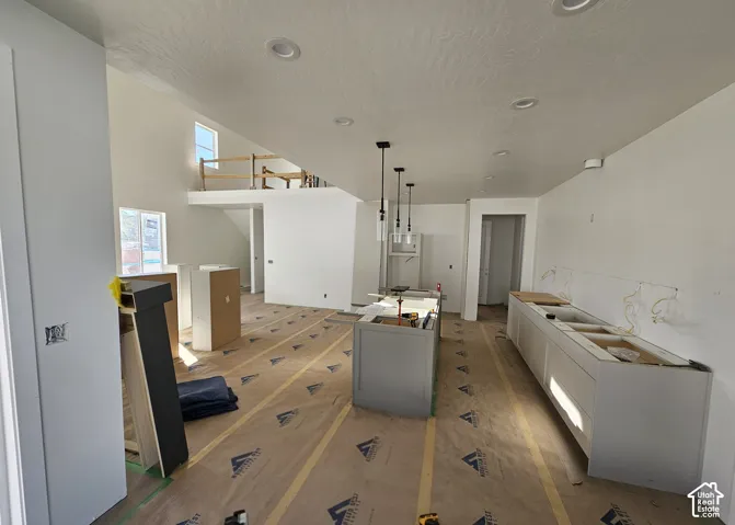 Open-concept layout with recessed lighting, kitchen island, and light-toned cabinetry