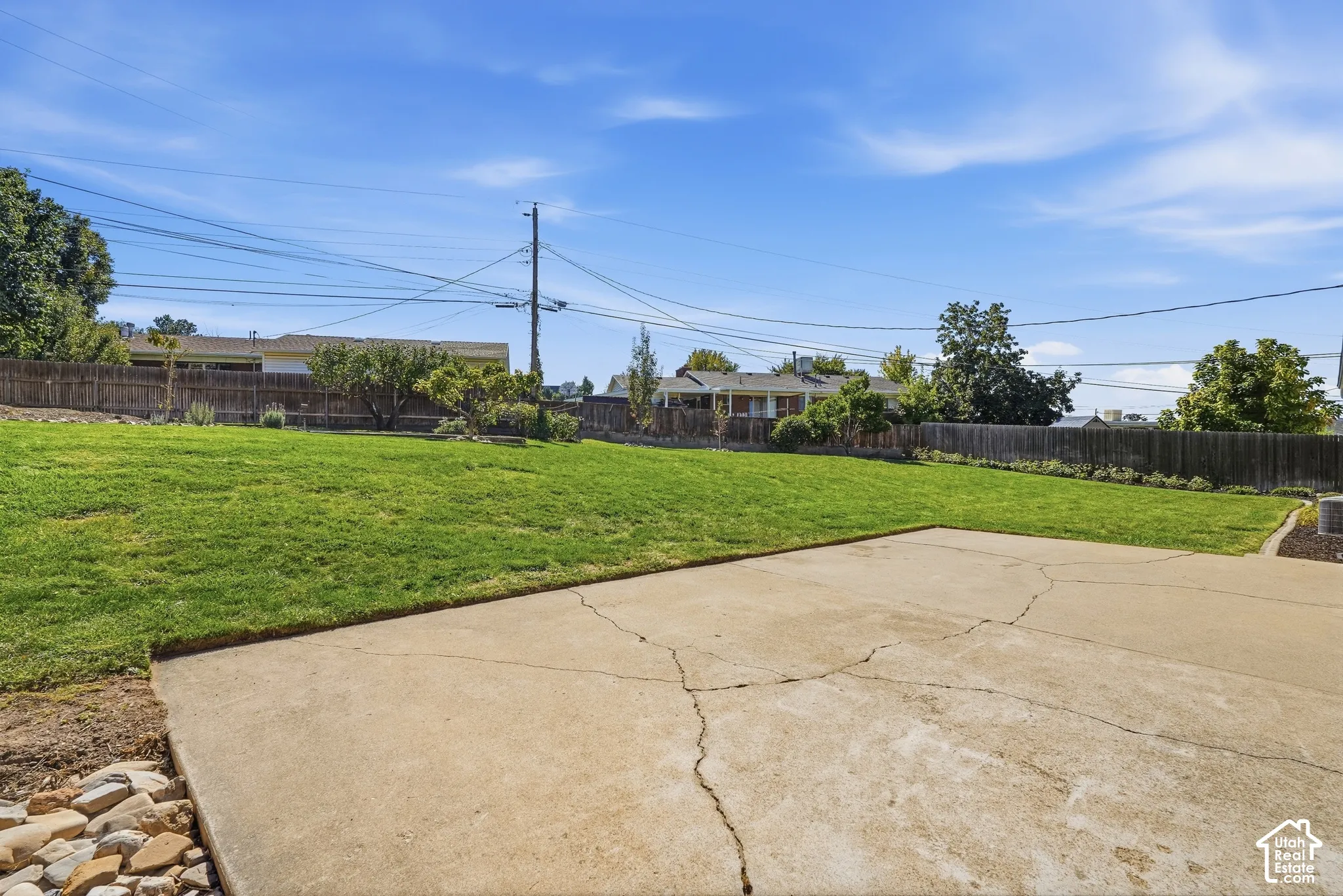 Expansive backyard featuring a lush lawn and concrete patio
