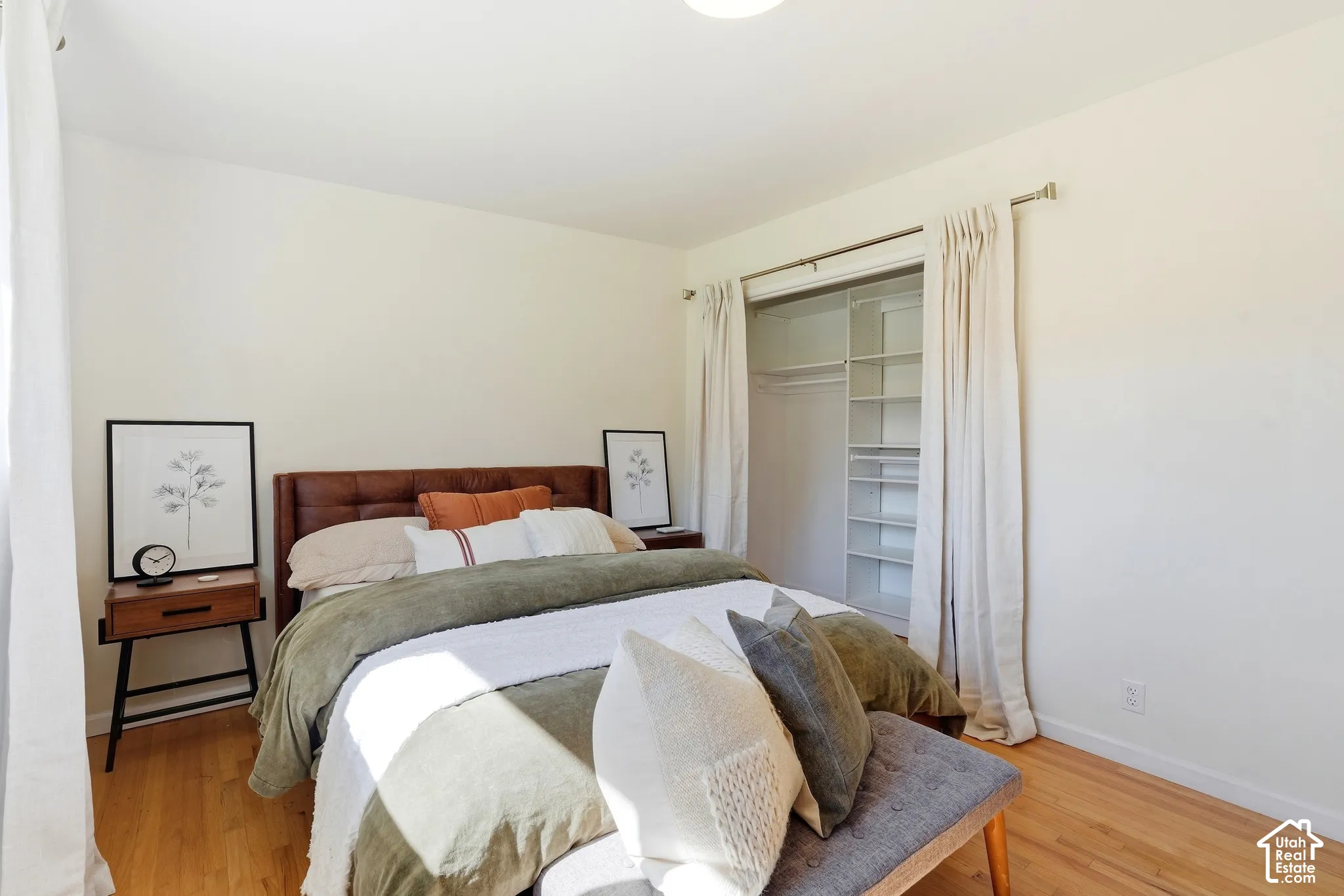 Hardwood-style flooring, white walls, built-in closet organization system, and recessed lighting
