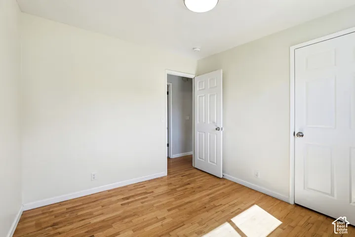Hardwood flooring, painted walls, white trim, and a flush mount light fixture