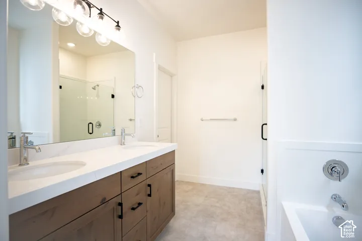 Primary bath with dual sinks, stained wood cabinet, quartz slab countertops, soaker tub and walk-in Euro shower.