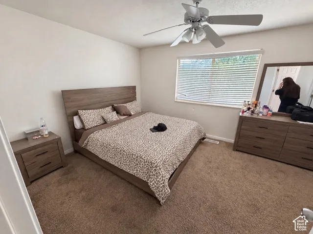 Ceiling fan with integrated lighting, window with horizontal blinds, neutral wall paint, and carpet flooring