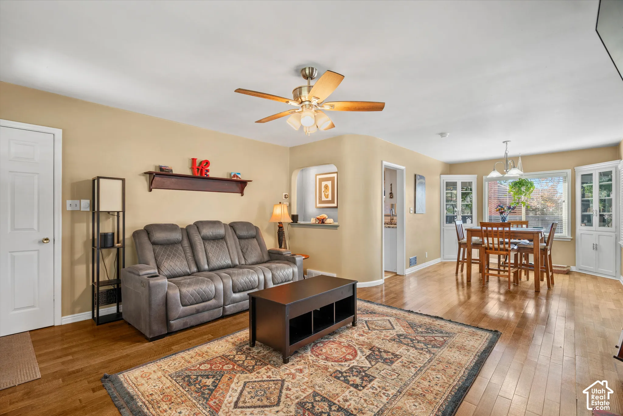 Hardwood flooring, ceiling fan, and built-in corner cabinetry