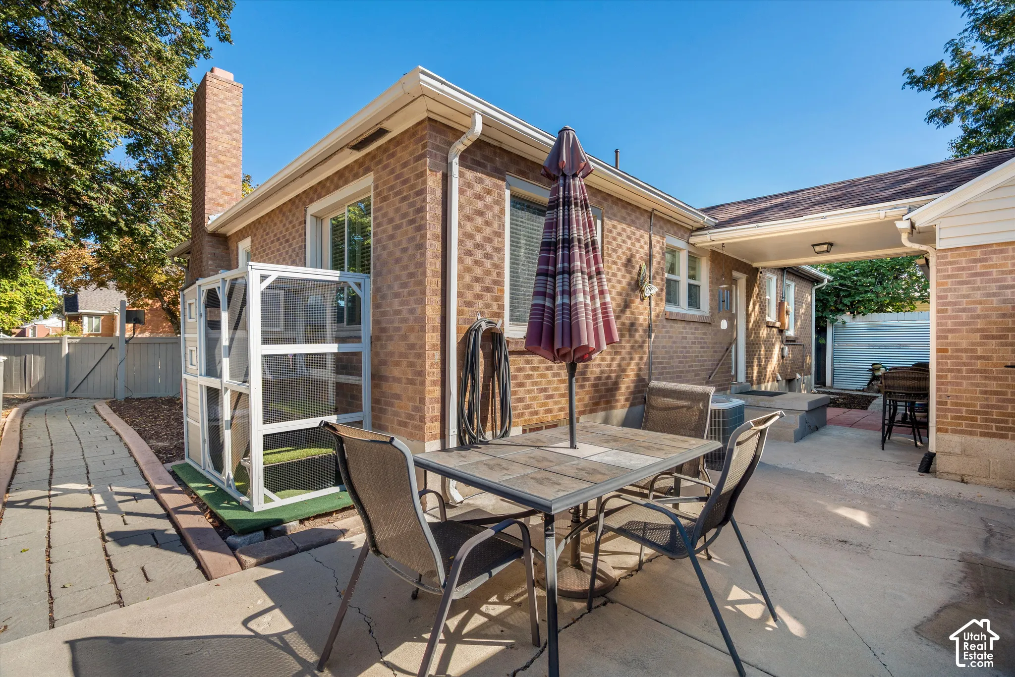 Brick exterior with a prominent chimney and a covered patio area