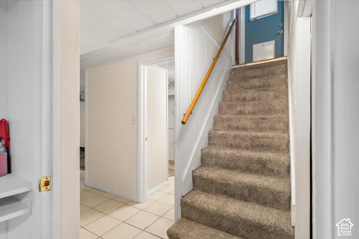 Carpeted staircase with a wood handrail