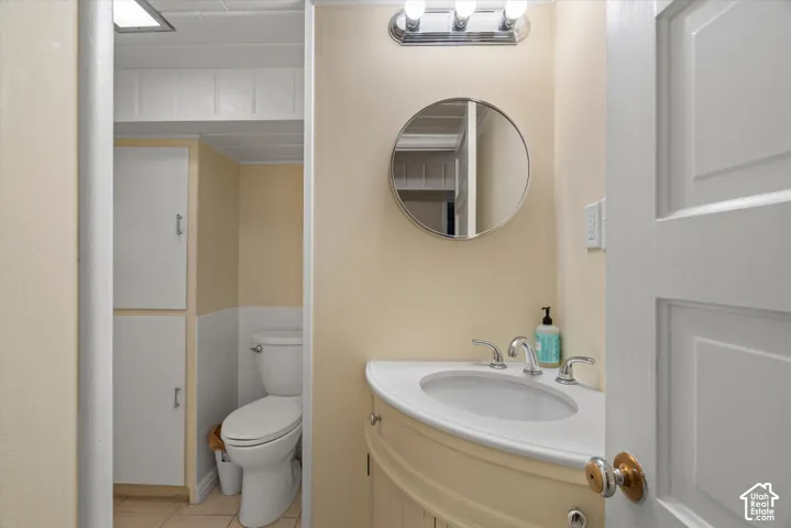 Vanity with integrated sink, chrome-finish faucet, and a circular mirror