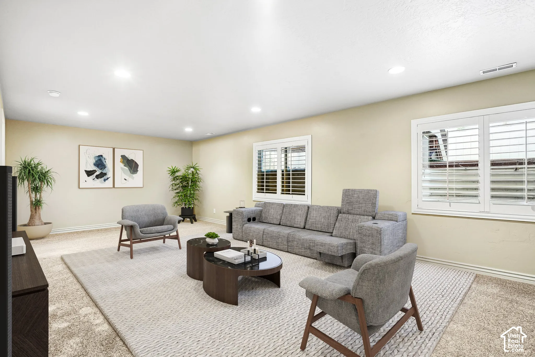 Recessed lighting illuminates the space, featuring carpeting and multiple windows with plantation shutters