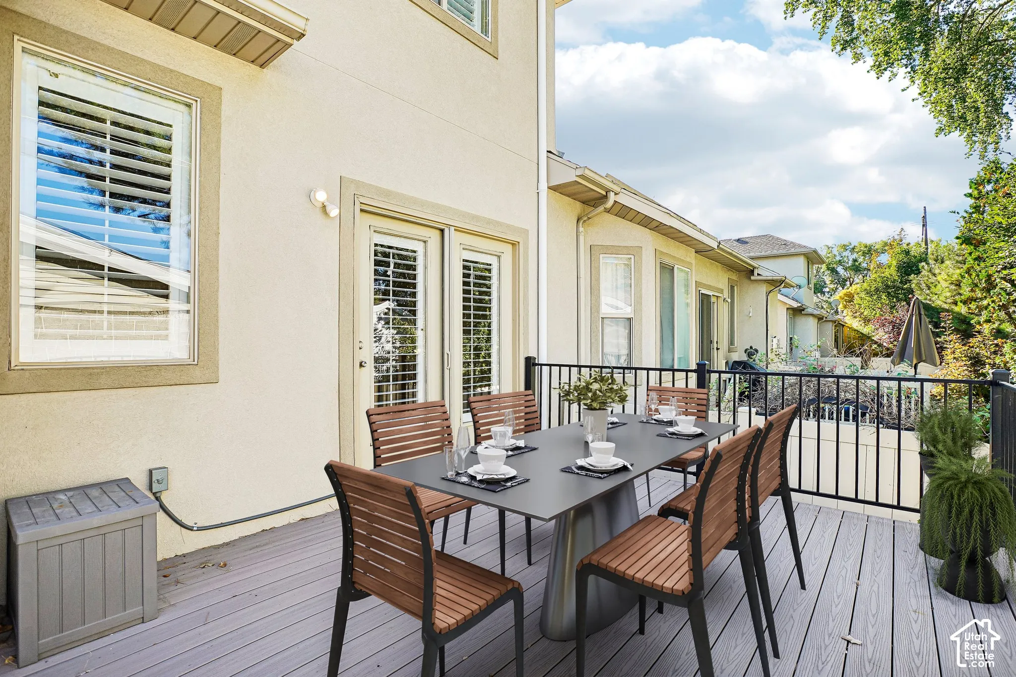 Outdoor deck featuring composite flooring, black metal railing, and direct access to interior via French doors