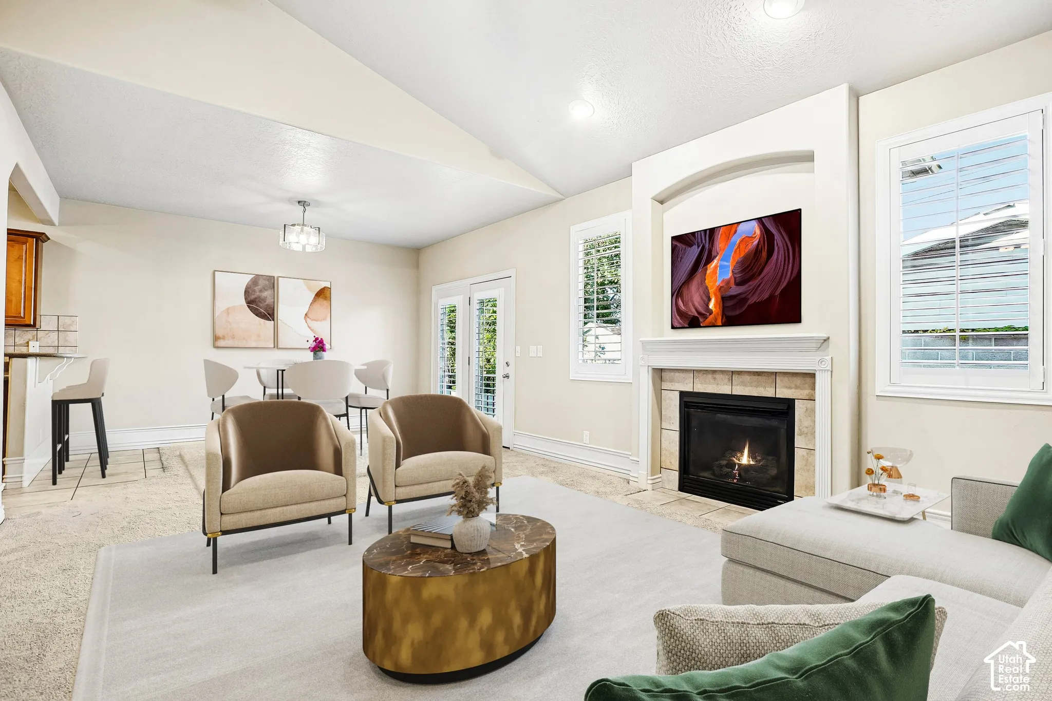 Living area featuring a vaulted ceiling and a fireplace with a tile surround and mantel