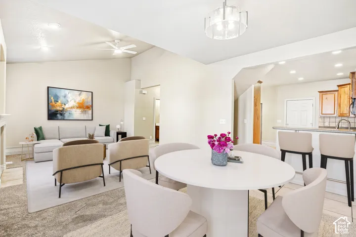 Vaulted ceiling with ceiling fan, recessed lighting, and a contemporary chandelier