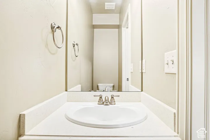 White countertop with an integrated oval sink and brushed nickel faucet