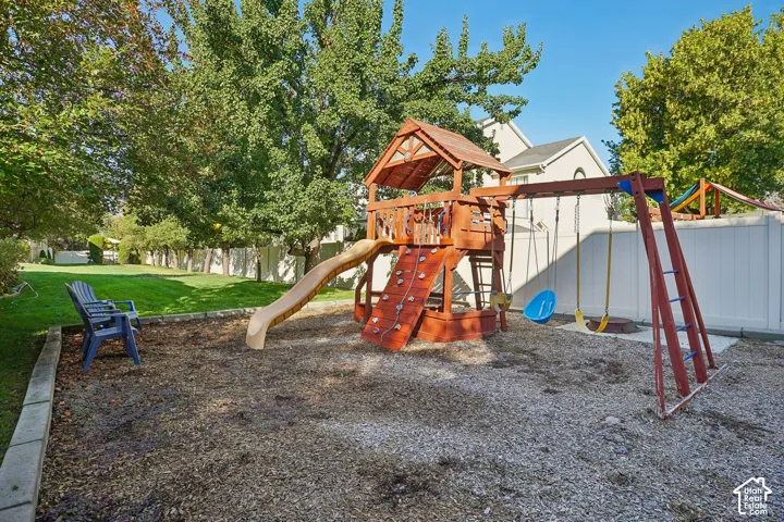 Expansive backyard featuring a manicured lawn, established trees, and a privacy fence