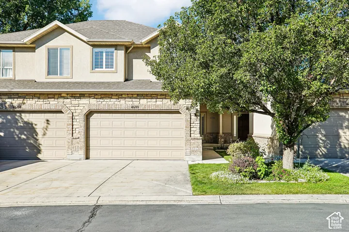 Two-story facade featuring stucco and stone veneer accents