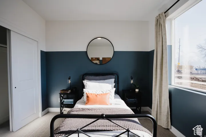 Recessed lighting, large window with ample natural light, two-tone painted wall, sliding closet doors, and neutral carpeting