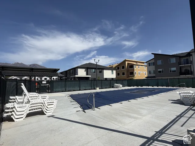 Concrete pool deck with perimeter fencing and a covered swimming pool