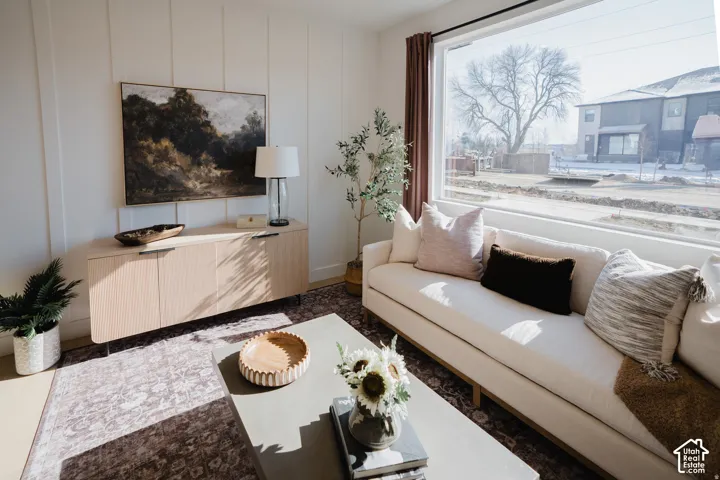 Expansive window framing exterior scenery, light wood-finish built-in cabinetry, and white paneled wall accent