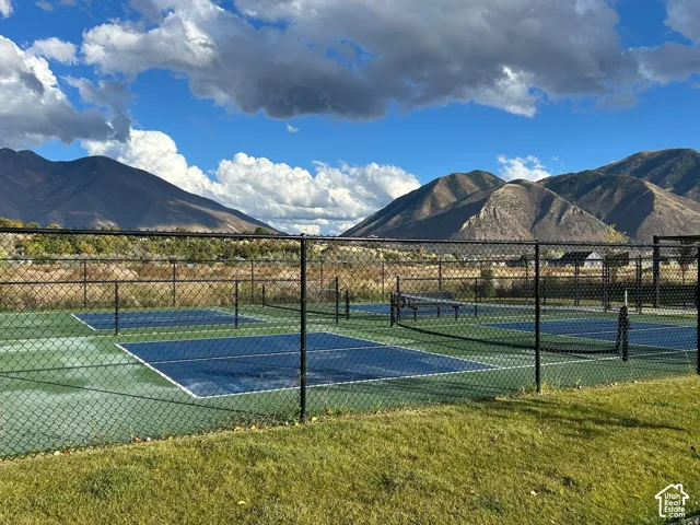 Fenced pickleball courts with mountain scenery