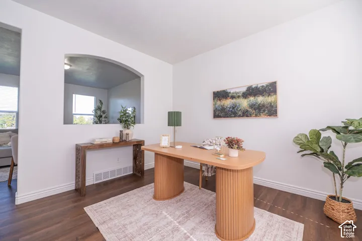 Wood-finish flooring, white wall paint, and an arched wall opening