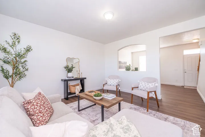 Recessed lighting, wood-finish flooring, arched interior wall opening, and a built-in wall niche