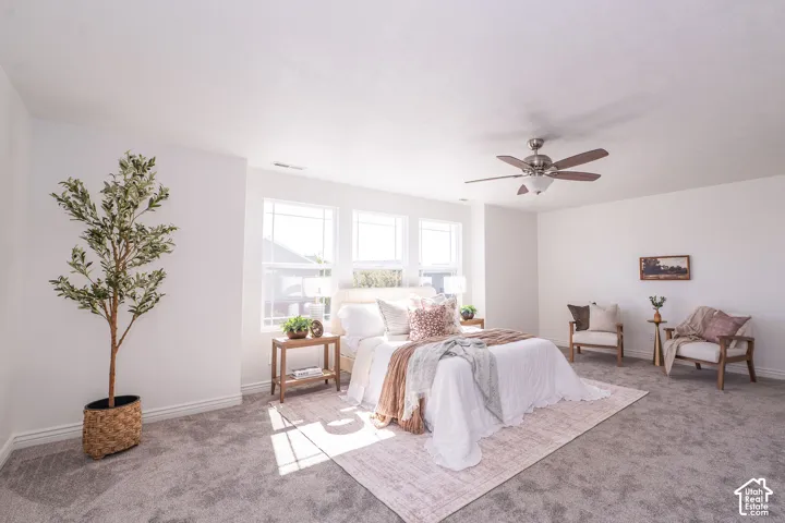 Recessed window with three panels, ceiling fan with integrated lighting, and neutral-toned wall-to-wall carpeting