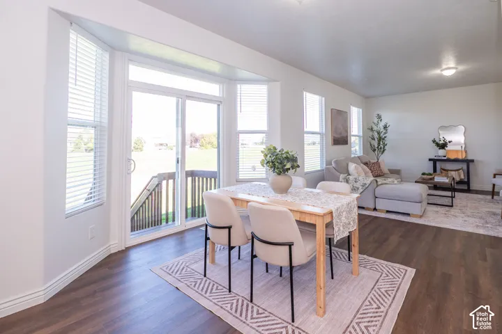 Wood-finish flooring throughout, bright white walls, and a sliding glass door leading to an outdoor deck