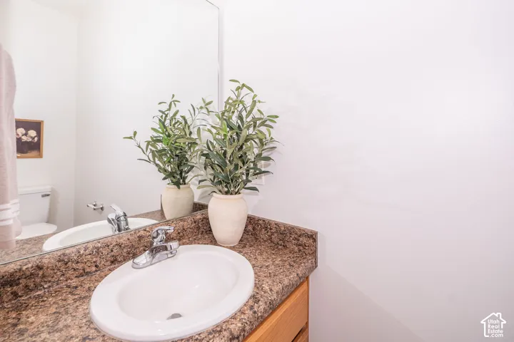 Built-in vanity with a stone-finish countertop, integrated oval sink, and chrome faucet