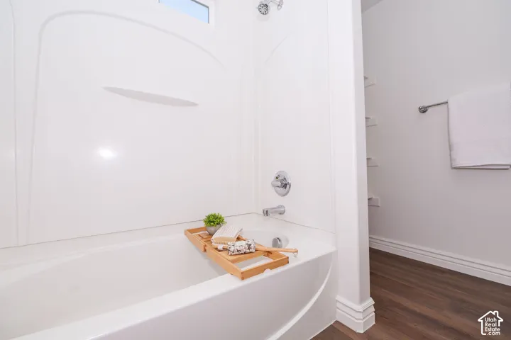 White acrylic tub and shower combination with chrome fixtures