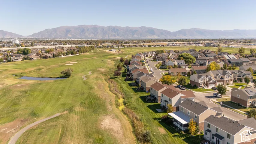 Residential community with mountain backdrop, adjacent golf course, and paved roadways