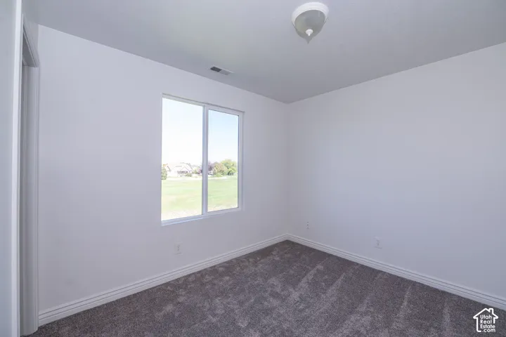 Carpeted flooring, white walls, and a double-pane window
