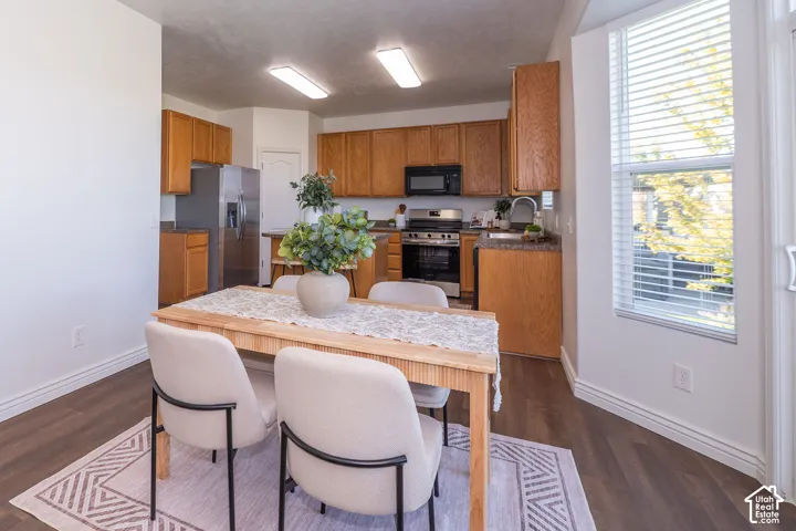 Kitchen featuring wood-finish cabinetry, stainless steel appliances, and dark countertops