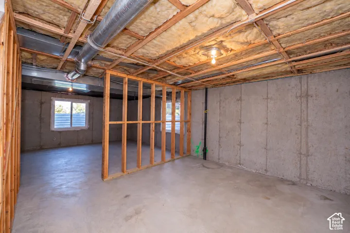 Unfinished basement area featuring exposed ceiling joists, insulation, and ductwork