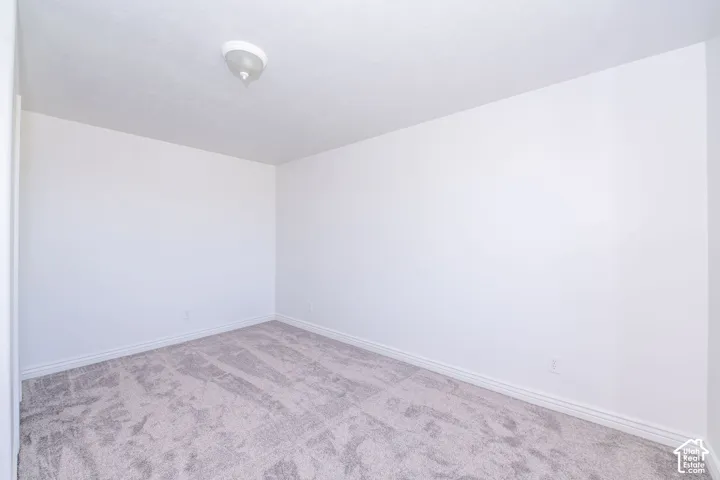 Neutral-toned carpet flooring with white baseboards and painted walls
