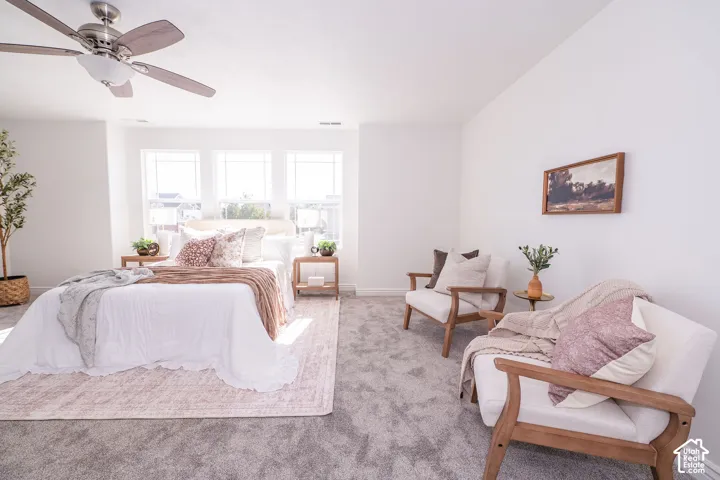 Recessed ceiling fan with light fixture, three windows with blinds, carpeted flooring, and built-in architectural elements