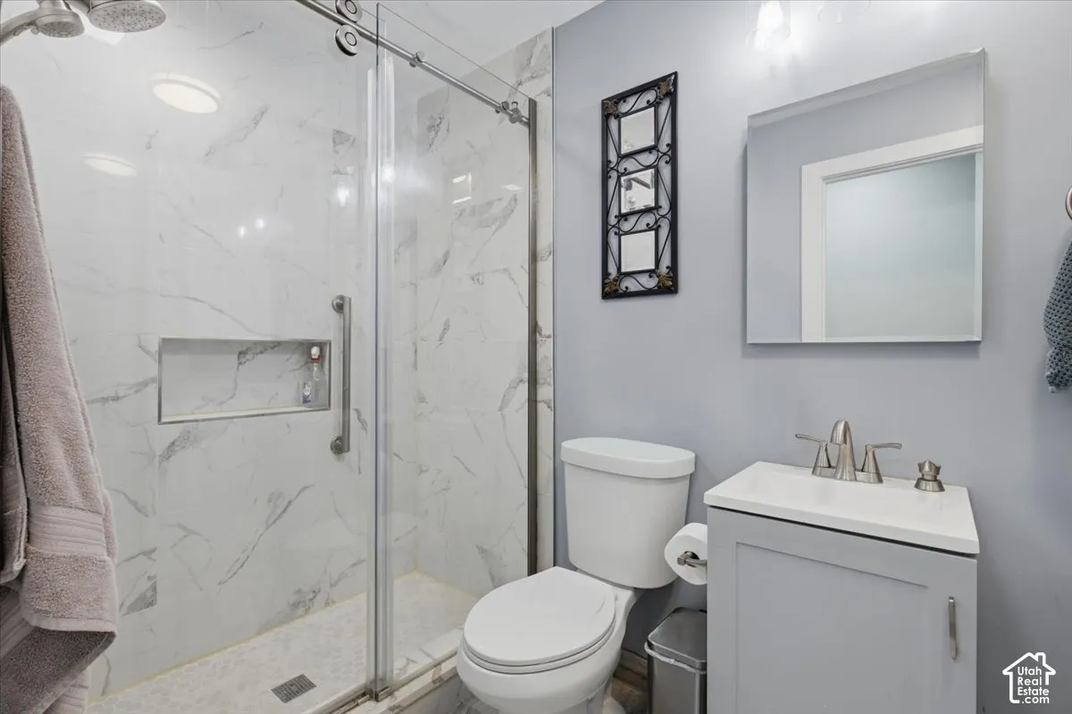 Glass-enclosed shower with a recessed niche, white subway tile, and a rainfall showerhead