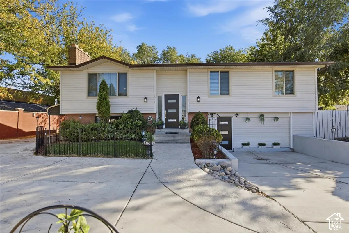 Split-level exterior with light-colored siding and a contrasting brown roof