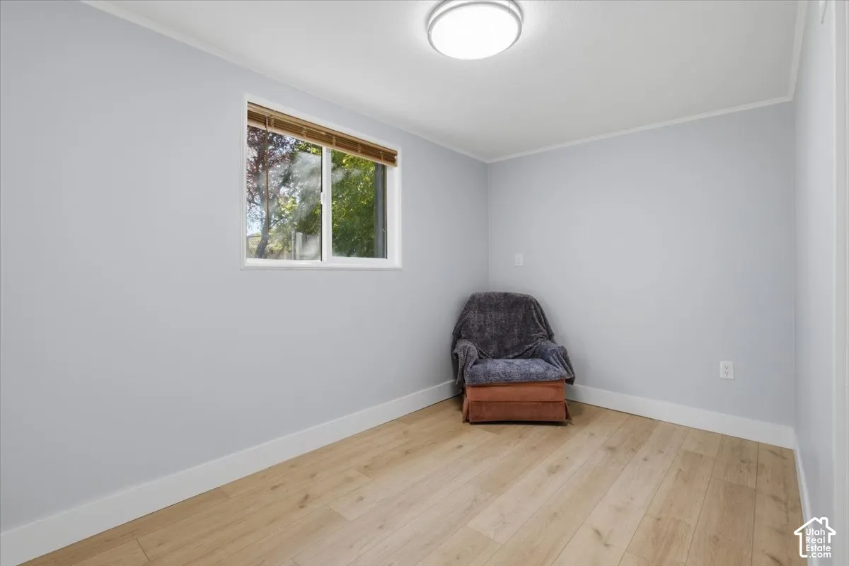 Wood-finish flooring, white trim, recessed lighting, and a white-framed window