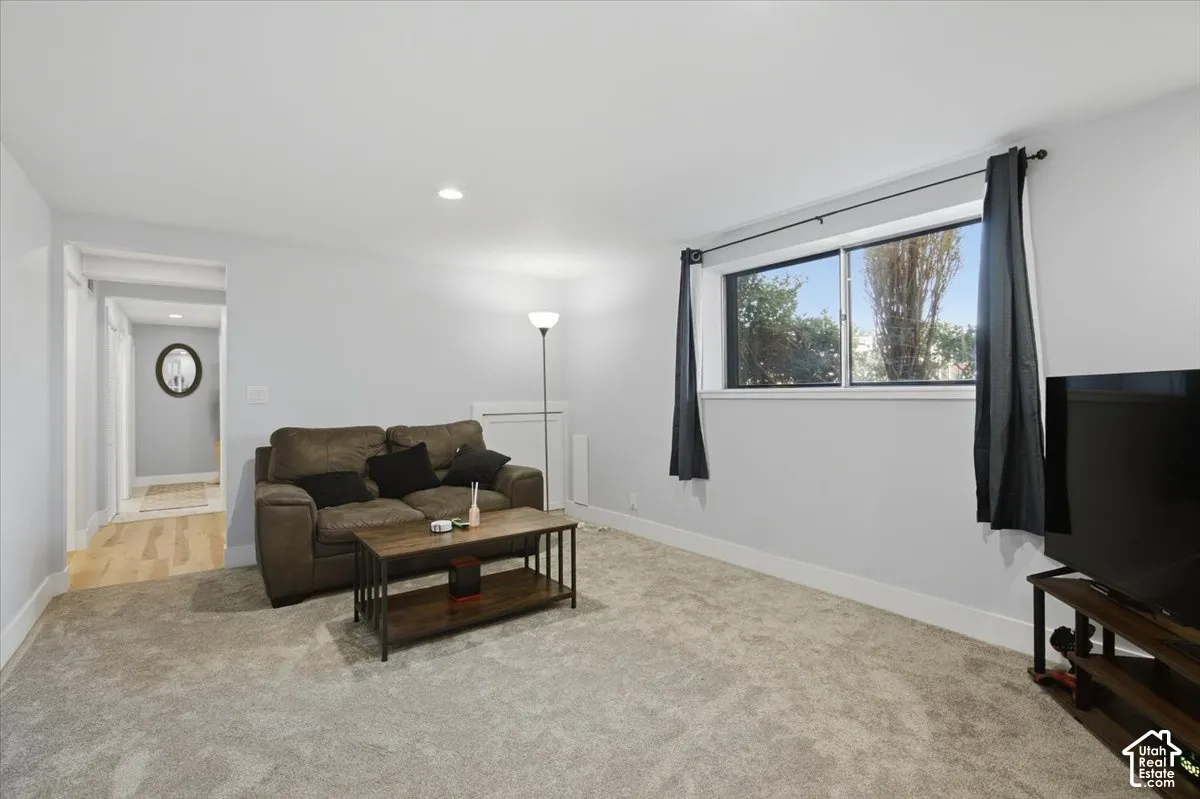 Recessed ceiling lighting, light gray wall paint, carpeting, white trim, and a window with exterior visibility