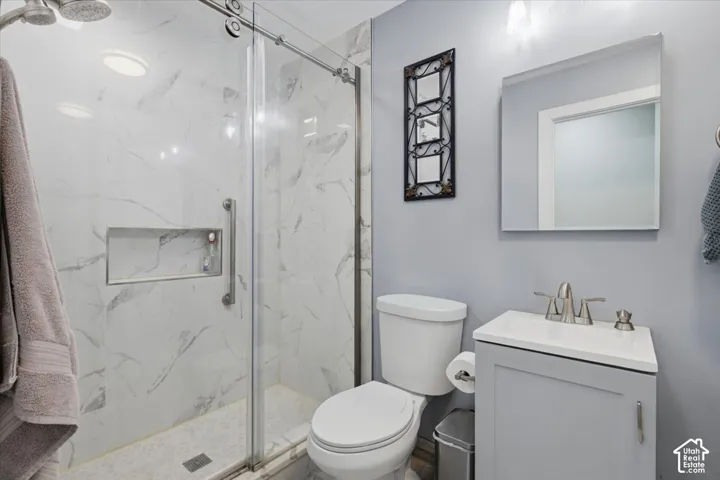 Glass-enclosed shower with a recessed niche, white subway tile, and a rainfall showerhead