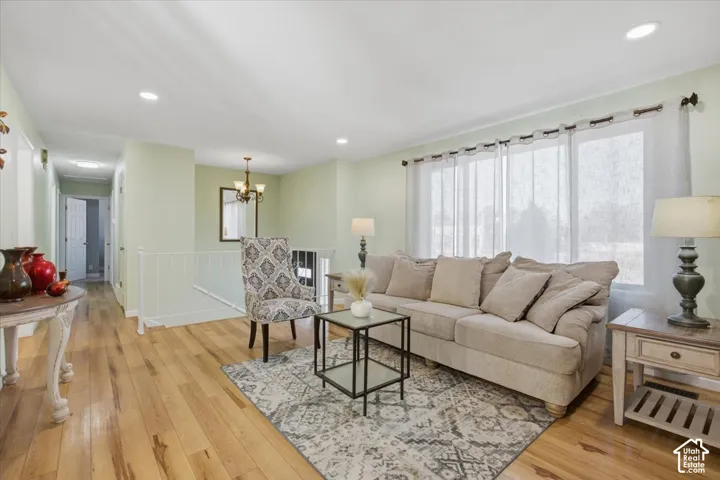 Hardwood-finish flooring, recessed ceiling lighting, prominent window wall, and a staircase with a white railing