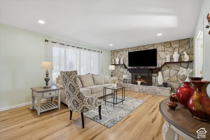 Stone-clad fireplace with integrated shelving, recessed lighting, and wood-finish flooring