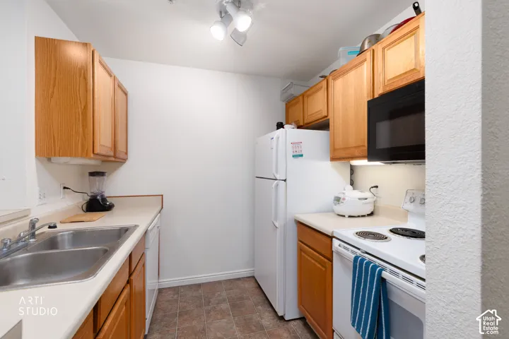 Kitchen featuring wood cabinetry, laminate countertops, a double basin sink, and a built-in microwave